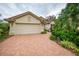 Tan house with beige garage door and manicured landscaping at 7117 Victoria Circle, University Park, FL 34201