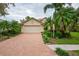 Home with brick driveway and tropical landscaping at 7117 Victoria Circle, University Park, FL 34201
