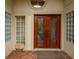 Double wood doors with glass accents and brick flooring at 7117 Victoria Circle, University Park, FL 34201