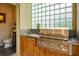 Outdoor kitchen with stainless steel grill and adjacent half-bath at 7117 Victoria Circle, University Park, FL 34201