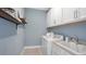 Bright laundry room with white cabinets and a utility sink at 8061 Moonbeam Ave, Sarasota, FL 34241