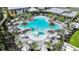 Aerial view of the community pool with a separate splash area, lounge chairs, umbrellas, and professional landscaping at 8105 Moonbeam Ave, Sarasota, FL 34241