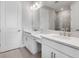 Bathroom boasting double sink vanity, white cabinets, large mirror and shower in background at 8105 Moonbeam Ave, Sarasota, FL 34241