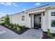 Inviting front entrance with a modern black door and meticulous landscaping at 8105 Moonbeam Ave, Sarasota, FL 34241