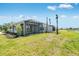 Backyard with pond view, landscaping, a covered patio, and views of neighboring homes at 8113 Moonbeam Ave, Sarasota, FL 34241