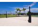 Community sand volleyball court with net, beach and palm tree surroundings at 8113 Moonbeam Ave, Sarasota, FL 34241