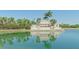 A water view of the 'Heritage Harbour' entrance sign with palm trees and landscaping at 8210 Eagle Isles Pl, Bradenton, FL 34212