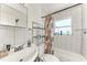 Bathroom with tiled shower, white sink, and window at 2003 Princeton Ave, Bradenton, FL 34207