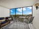 Screened balcony with seating, table, and serene views of the surrounding community at 2045 Gulf Of Mexico Dr # M1-502, Longboat Key, FL 34228