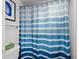 Close-up of a shower with a blue and white striped shower curtain at 2045 Gulf Of Mexico Dr # M1-502, Longboat Key, FL 34228