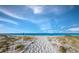 Sandy path leading to beach with lounge chairs and umbrellas at 2045 Gulf Of Mexico Dr # M1-502, Longboat Key, FL 34228