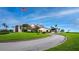 Clubhouse exterior with a paved driveway, grassy area, and American flag at 2045 Gulf Of Mexico Dr # M1-502, Longboat Key, FL 34228