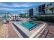 Community pool and hot tub with lounge chairs and umbrellas at 2045 Gulf Of Mexico Dr # M1-502, Longboat Key, FL 34228