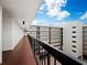 Outdoor walkway with brick flooring and black metal railings, overlooking the courtyard at 2045 Gulf Of Mexico Dr # M1-502, Longboat Key, FL 34228