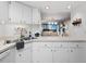 Compact kitchen with white cabinets and sink at 2045 Gulf Of Mexico Dr # M1-502, Longboat Key, FL 34228