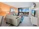 Living area featuring gray leather furniture, a large TV, and a balcony with a scenic view at 2045 Gulf Of Mexico Dr # M1-502, Longboat Key, FL 34228