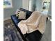 Close-up of a black couch with throw pillows and blanket at 222 27Th W St, Bradenton, FL 34205