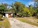 Ranch home with a spacious front yard, mature trees, and colorful landscaping at 3181 Irving St, Sarasota, FL 34237