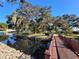 A wooden footbridge over a calm body of water in a lakeside community at 3416 Spanish Oak Ter, Sarasota, FL 34237