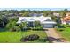 An aerial view showcasing the home's white tiled roof, surrounded by a well-maintained lawn and neighboring properties at 348 Red Ash Cir, Englewood, FL 34223