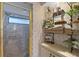 Bathroom with gold-framed shower, glass shelves, and tiled walls at 348 Red Ash Cir, Englewood, FL 34223