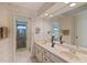 Double vanity bathroom with large mirror, shower, and tiled floor at 348 Red Ash Cir, Englewood, FL 34223