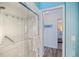 Bathroom with a walk-in shower, tiled walls, and a glimpse of the adjacent bedroom at 348 Red Ash Cir, Englewood, FL 34223
