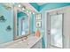 Bright blue bathroom featuring a single vanity, a large mirror, and access to the outdoors at 348 Red Ash Cir, Englewood, FL 34223