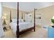 Cozy bedroom with four-poster bed, carpeted floors, and beach-themed artwork at 348 Red Ash Cir, Englewood, FL 34223