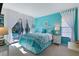 Bright bedroom with teal walls, white furniture, and sliding door access to the outdoors at 348 Red Ash Cir, Englewood, FL 34223