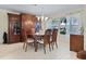 Elegant dining room with a round table, wooden hutch, and tiled hexagonal flooring at 348 Red Ash Cir, Englewood, FL 34223