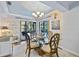 Dining room with glass-top table, wooden chairs, and view of pool through sliding doors at 348 Red Ash Cir, Englewood, FL 34223