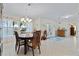 Dining area with a round wooden table, white tiled hexagonal flooring, and views to the outdoors at 348 Red Ash Cir, Englewood, FL 34223