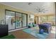 Florida room with sliding glass doors, ceiling fan, comfortable seating, and a TV at 348 Red Ash Cir, Englewood, FL 34223