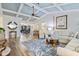 Coastal-themed living room featuring vaulted ceilings with light blue accents, wood floors, and comfortable seating at 348 Red Ash Cir, Englewood, FL 34223