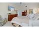 Spacious main bedroom with wooden furniture, a ceiling fan, and a mounted TV at 348 Red Ash Cir, Englewood, FL 34223