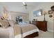Main bedroom featuring wooden furniture, ceiling fan, wall-mounted TV, and pool view at 348 Red Ash Cir, Englewood, FL 34223