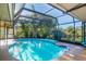 Inviting pool surrounded by lush landscaping and enclosed by a screen at 348 Red Ash Cir, Englewood, FL 34223