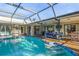 A spacious caged pool with a sitting area and steps leading into the inviting blue water at 348 Red Ash Cir, Englewood, FL 34223