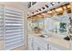 Convenient wet bar with wine storage, sink, and mirrored backsplash at 348 Red Ash Cir, Englewood, FL 34223