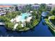 Stunning aerial view showcasing a pool, lush greenery, and serene waters, nestled amidst condo buildings at 350 Gulf Of Mexico Dr # 211, Longboat Key, FL 34228