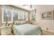 Cozy bedroom with light green bedding, white furniture, and soft carpeting at 350 Gulf Of Mexico Dr # 211, Longboat Key, FL 34228