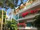 Exterior of a condo building adorned with colorful flowers and balconies at 350 Gulf Of Mexico Dr # 211, Longboat Key, FL 34228