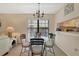 Bright dining area with glass table and four chairs, view to kitchen at 4767 Winslow Beacon # 25, Sarasota, FL 34235