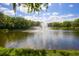 Serene fountain in a pond surrounded by trees at 4767 Winslow Beacon # 25, Sarasota, FL 34235