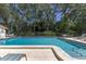 Community pool with lounge chairs and umbrellas at 4767 Winslow Beacon # 25, Sarasota, FL 34235