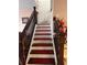 Classic staircase with wooden banister and carpeted steps at 5630 3Rd W St, Bradenton, FL 34207