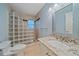 Bathroom with glass block shower, granite vanity, and decorative mirror at 7056 Saddle Creek Ln, Sarasota, FL 34241