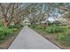 Paver driveway through mature trees leading to a charming home with a detached building at 7056 Saddle Creek Ln, Sarasota, FL 34241