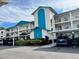 Condo building with teal accents, parking, and landscaping at 7301 29Th Avenue W Dr # 206, Bradenton, FL 34209